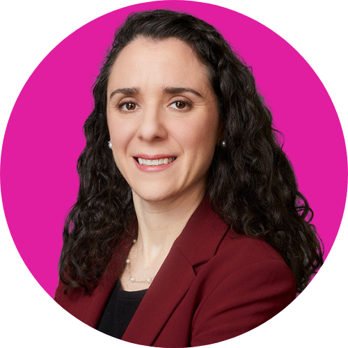 Professional headshot: woman with dark curly hair, burgundy blazer, smiling against a magenta circular background.