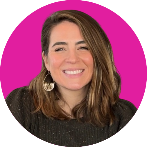 Smiling woman with shoulder-length brown hair and geometric gold earrings, wearing a black top, against a magenta circular background and white backdrop.