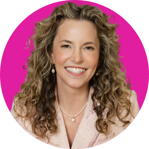 Smiling woman with long curly hair wearing a light blazer, against a bright pink circular background, portrait photo