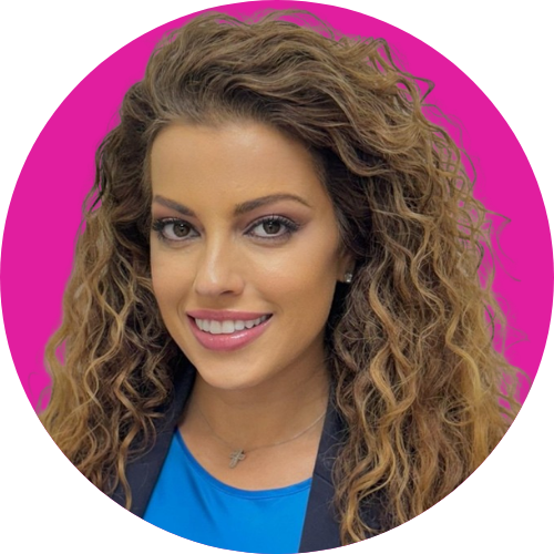 Professional headshot of a smiling woman with curly brown hair, wearing a blue top and dark blazer, against a magenta circular background.
