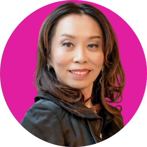Portrait of a smiling woman with shoulder-length dark hair, wearing a black blazer, against a magenta circular background.