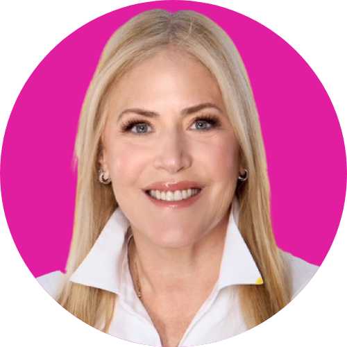 Smiling blonde woman in a white collared shirt against a pink circular background.