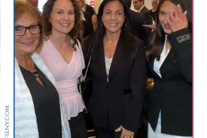 Group of professionally dressed women posing together at a formal event, with 'Top Lawyers of Long Island' branding above.