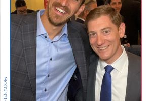 Two men in suits posing and smiling at a formal event, with a 'Top Lawyers of Long Island' frame above them.