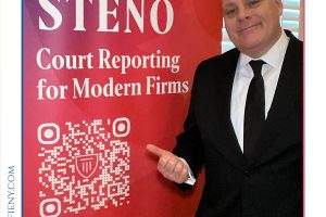 Man in a black suit and tie standing next to a red STENO banner reading 'Court Reporting for Modern Firms' with a QR code nearby