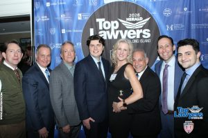 Group of professionals posing for a photo at the 2026 Top Lawyers of Long Island event in front of a blue sponsor backdrop