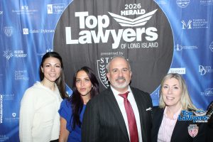 Group of four professionals posing at the 2026 Top Lawyers of Long Island event in front of a blue sponsor banner.