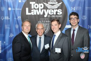 Four men in suits posing at a 'Top Lawyers of Long Island' backdrop.
