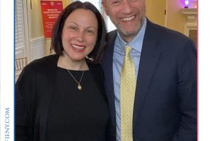 Smiling man in a navy suit and yellow tie posing with a woman in black, at the 2026 Top Lawyers of Long Island event.