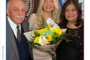 Three people pose with a bouquet at the 2026 Top Lawyers of Long Island awards event, with banners in the background.