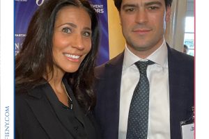 Two professionally dressed individuals posing at a law awards event with a 'Top Lawyers of Long Island' backdrop in the background.