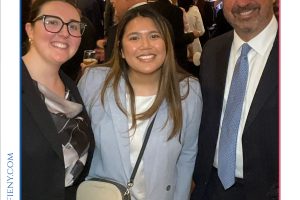 Three smiling attendees pose together at a 2026 Top Lawyers of Long Island event, with a banner in the background and dressed in business attire.