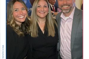Three smiling professionals posing together at the 2026 Top Lawyers of Long Island event, with a blue backdrop behind them.