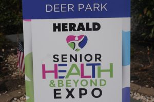 Welcome sign for Deer Park Senior Health & Beyond Expo with Herald logo, outdoors on a stand