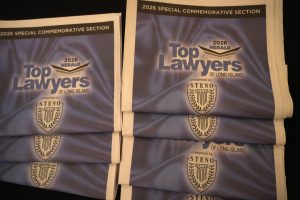 Stacks of blue posters reading 'Top Lawyers of Long Island' with a crest and the note '2026 Special Commemorative Section'.