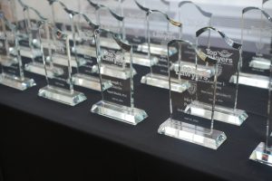 Several glass 'Top Lawyers' awards lined up on a black table, ready for presentation at an event.