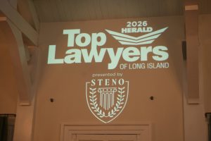 Projection on a wall reading '2026 Top Lawyers of Long Island' with a shield crest and 'presented by STENO' beneath it.