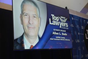 Portrait of Allen L. Bode, keynote speaker at the 'Top Lawyers of Long Island' event, with banner text in the background.