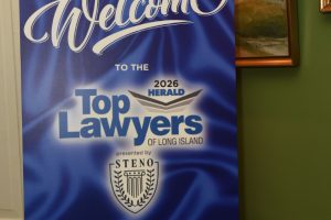 Blue welcome sign announcing the 2026 Herald Top Lawyers of Long Island, dated April 22, 2026, with an emblem and decorative text.