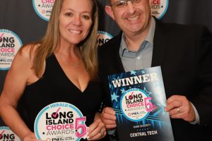 Two smiling award winners pose together in front of a step-and-repeat banner, each holding Long Island Choice Awards badges; the man also holds a winner certificate labeled Central Tech or similar.