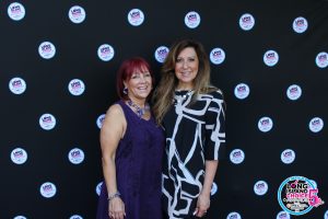 Two smiling women posing for a photo in front of a black backdrop with Long Island Choice Awards logos.
