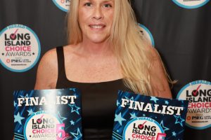 Woman with long blond hair holding two 'FINALIST' awards for Long Island Choice Awards, Beach Terrace Care Center, against a backdrop of award logos.