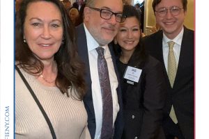 Four professionals in business attire pose for a group photo at a formal event, with 'Top Lawyers of Long Island' branding visible above.