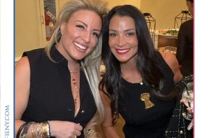 Two smiling women in black dresses posing with drinks at a social Top Lawyers event.