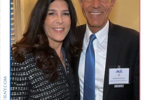 Smiling man and woman posing for a photo at a Top Lawyers of Long Island event, with the event logo above and an honoree badge on the man's jacket.