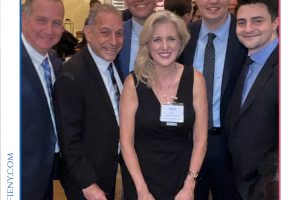 Group of five professionals in suits and a black-dress woman posing together at a formal awards reception (Top Lawyers of Long Island).