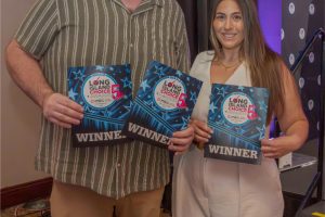Two winners pose for a photo at an awards event, each holding a blue certificate that reads WINNER with the Long Island Choice Awards logo.